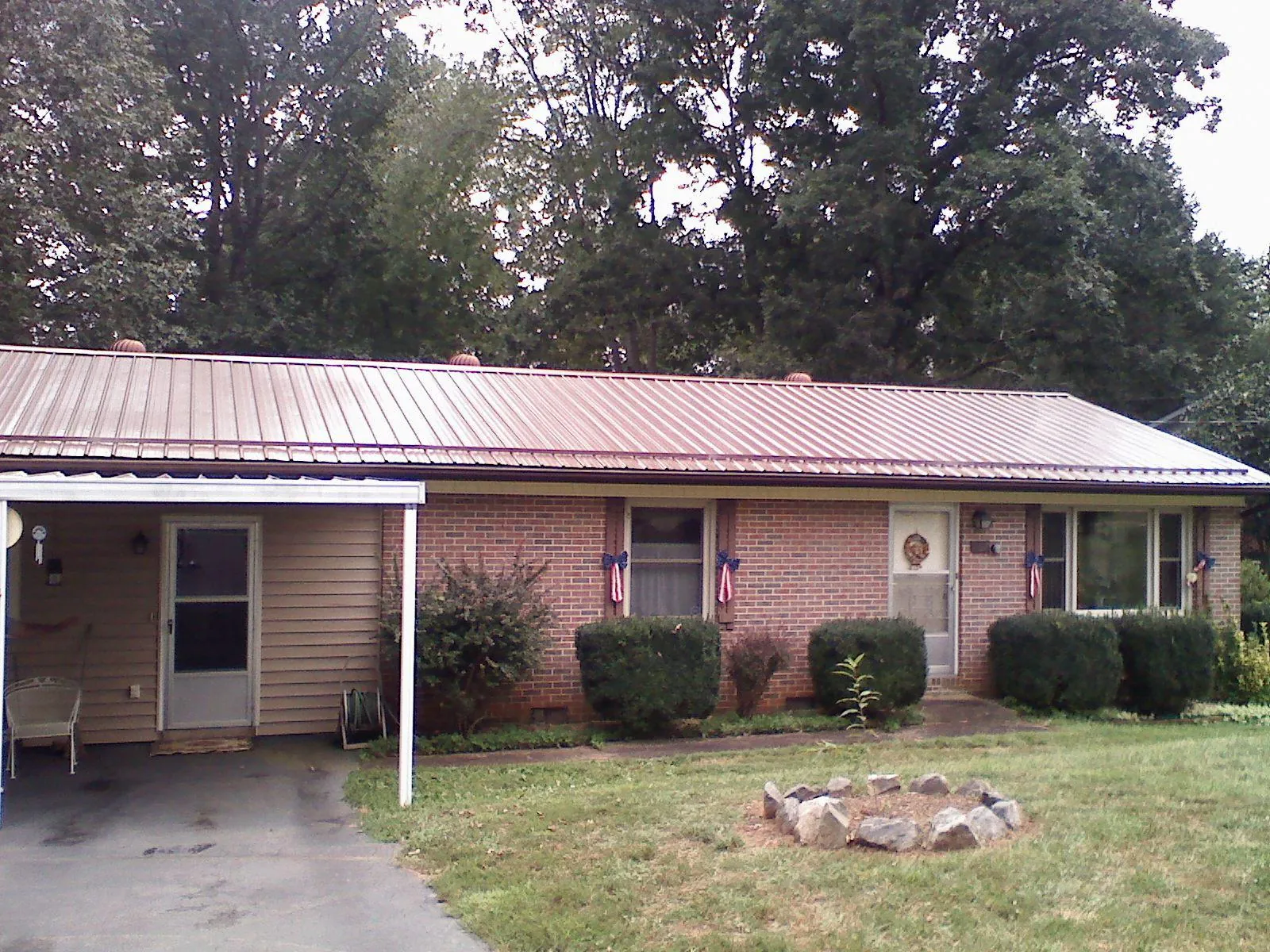 Bronze metal roof and carport on a brick ranch home — Roof Repair work by our crew in Adair